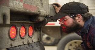 Truck driver inspecting brake lights