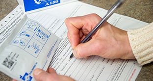 Person holding Drug and Alcohol kit and filling out form