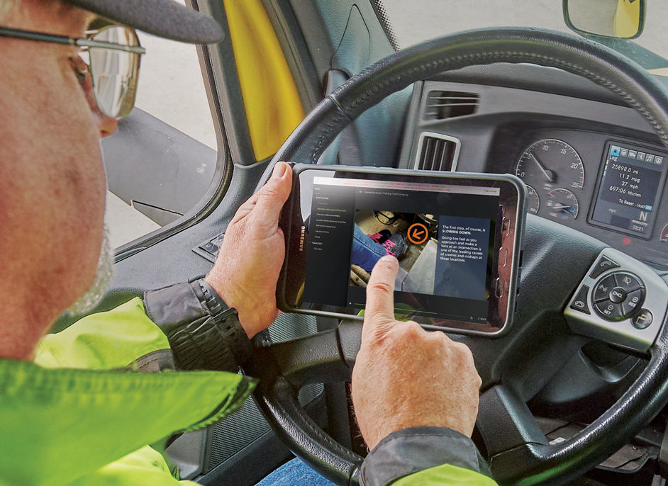 Driver in cab doing training on tablet