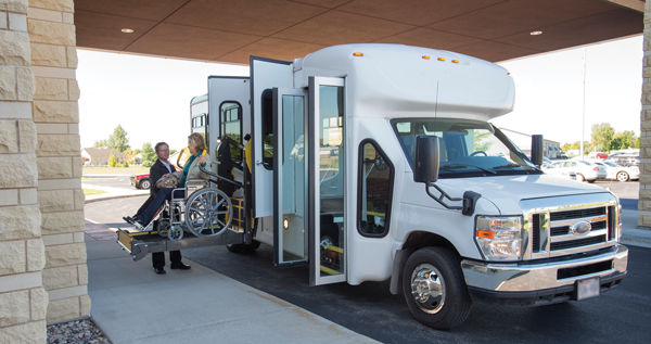 passenger in wheelchair on chair lift into van