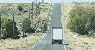 Semi driving away on country road