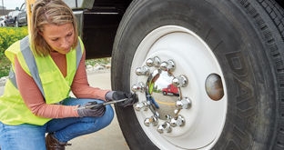 Driver checking tire pressure