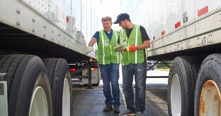 Carrier and driver inspecting trailer