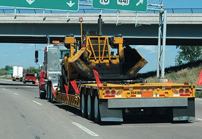 Truck with construction equipment on flatbed trailer