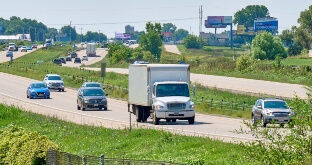 Box truck driving on busy road