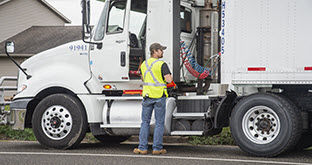 Driver standing by semi truck