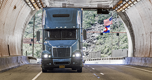 Blue semi driving through tunnel