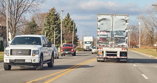 Pickup trucks and semis on four-lane road